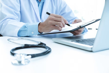 doctor-working-with-laptop-computer-writing-paperwork-hospital-background_1421-69.avif.jpg